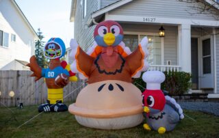 Outdoor Thanksgiving inflatable decorations plugged into exterior outlets, illustrating safe holiday electrical setup with weatherproof covers and GFCI protection for Minnesota homes.